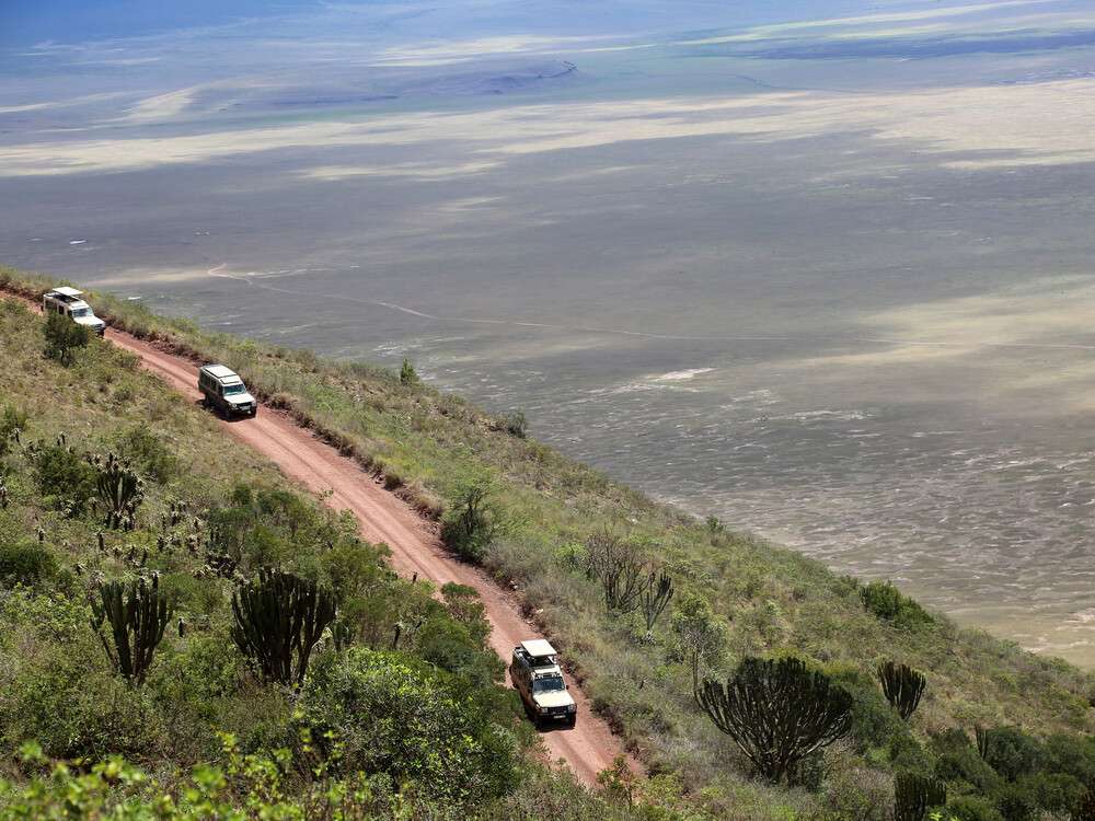 Safari vehicles descending a road into Ngorongoro Crater